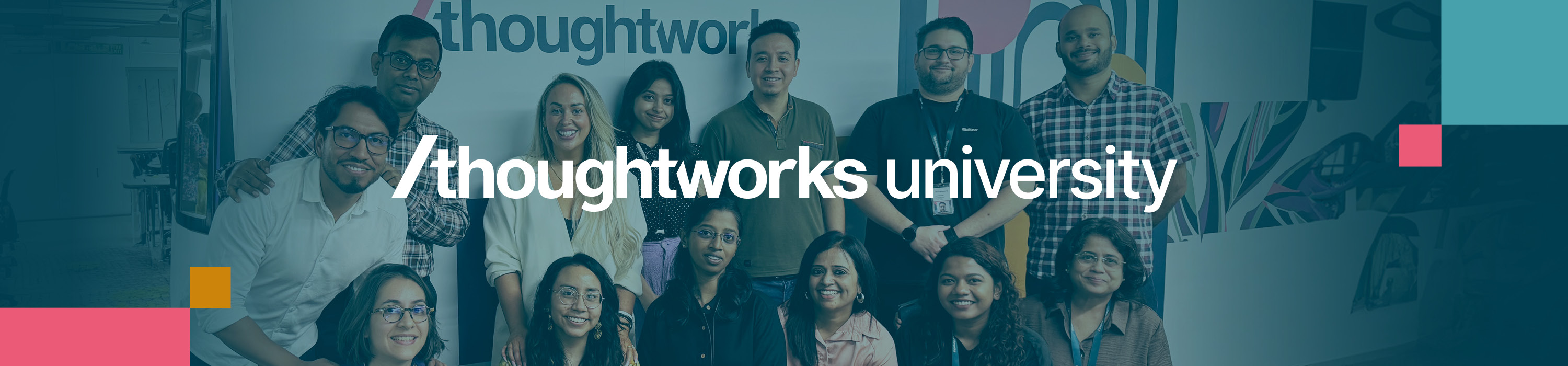 Group of Thoughtworkers in front of a blue wall featuring the Thoughtworks University logo in bold white text.