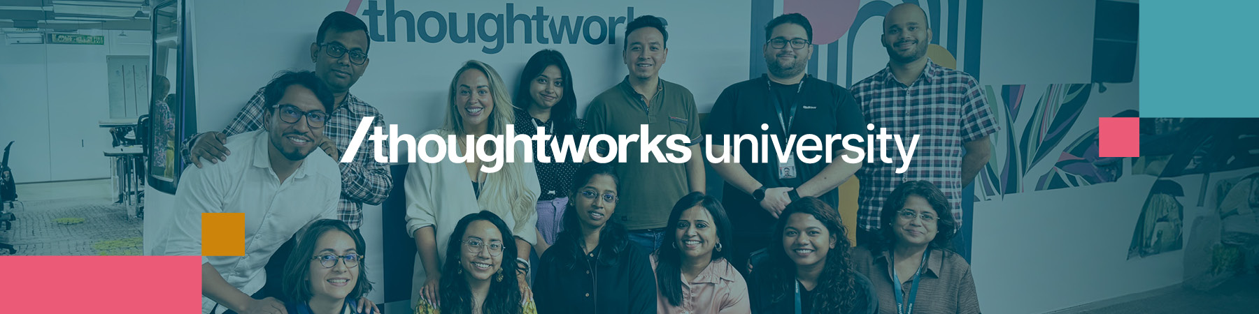 Group of Thoughtworkers in front of a blue wall featuring the Thoughtworks University logo in bold white text.